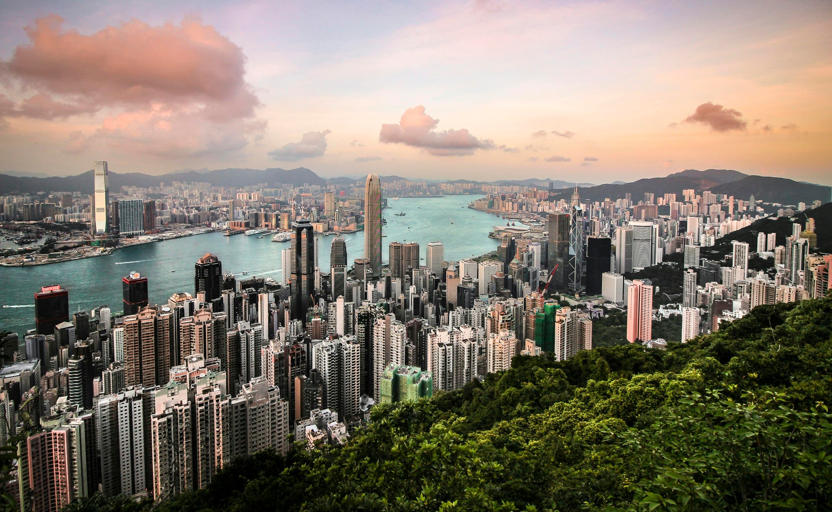 Hong Kong skyline and Victoria Harbour seen from Victoria Peak in warm evening light.